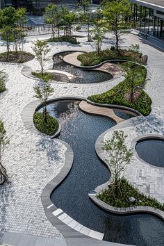 an aerial view of a park with many trees and small water features on the ground