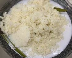 rice and asparagus in a bowl on a plate with silver trimmings