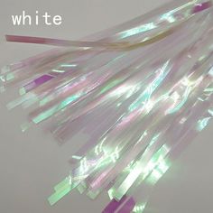 a bunch of white and purple streamers hanging from a string with the words whitte on it