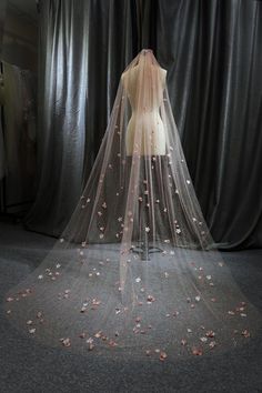 a wedding veil with pink flowers on it