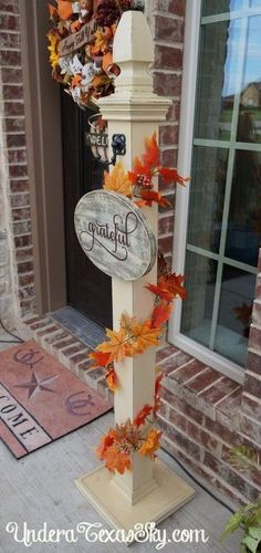 a clock decorated with fall leaves in front of a door