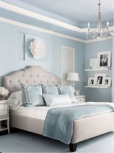 a bed room with a neatly made bed and a chandelier