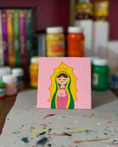 a card with a painting of a woman in the middle of it on a table