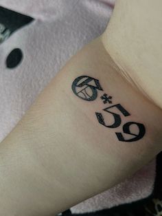 a person with a tattoo on their arm and the number fifty six in black ink