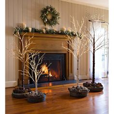 a living room filled with furniture and a fire place covered in fake tree's