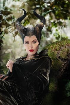 a woman with horns on her head and black makeup