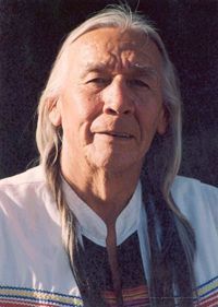 an old man with long hair wearing a white shirt