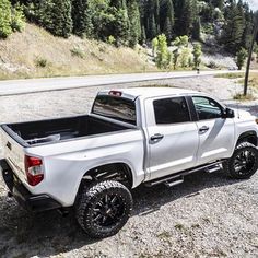 a white truck parked on the side of a road