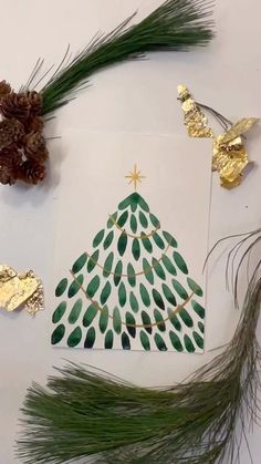 some pine cones are sitting next to a christmas tree with green leaves and gold foil on it