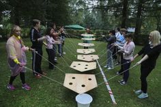 a group of people standing around a wooden board game