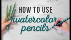 two hands are writing how to use watercolor pencils on a white marble surface