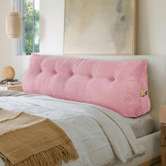 a bed with a pink pillow on top of it