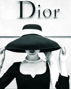 a woman wearing a black and white hat with the word dior on it's side