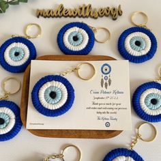 blue and white evil eye keychains are on display in front of a card