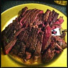 a yellow plate topped with sliced steak on top of a table