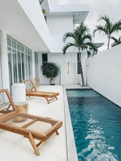 two lounge chairs sitting next to a swimming pool