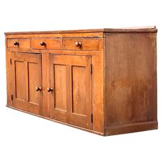 an old wooden cabinet with three doors and two drawers on one side, against a white background