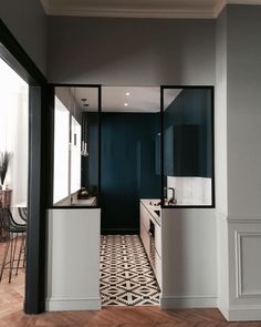 an empty kitchen with black and white flooring in the center, along with wooden floors