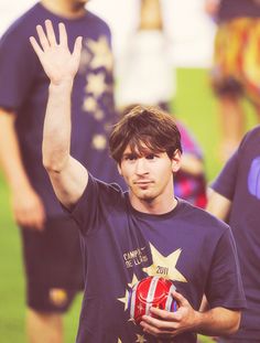 a young man is holding his hand up in the air while other people stand behind him