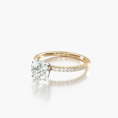 a yellow gold engagement ring with a single diamond in the center and side stones on each band