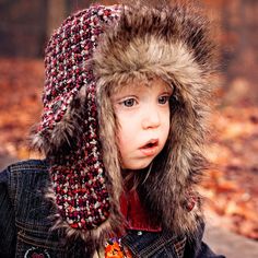 a young child wearing a hat and jacket