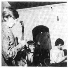 two young boys are playing guitar in an old photo