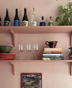 the shelves are filled with wine glasses, books, and other decorative items on top of them