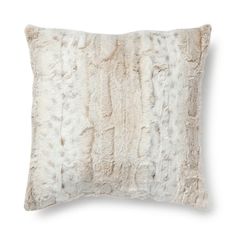 a white pillow with fur on the front and back, it is made out of sheepskin