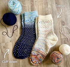 three pairs of socks and two balls of yarn on the floor with instructions for knitting them