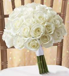 a bouquet of white roses is sitting on a chair