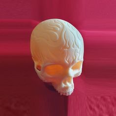 a white human skull sitting on top of a pink surface next to a red wall