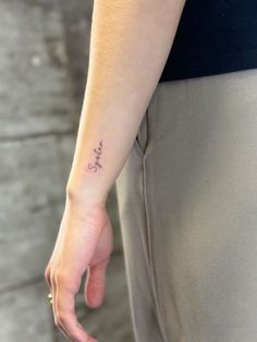 a person with a small tattoo on their left arm and the word love written in cursive writing