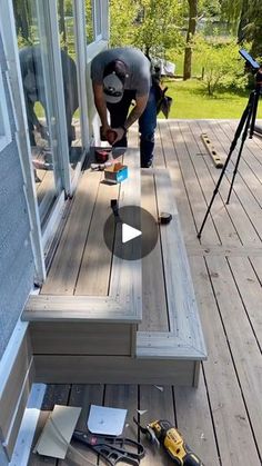 a man is working on the outside of a house with wood floors and sidings