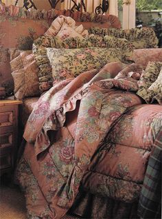 a bed covered in lots of pillows and blankets