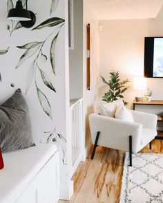 a living room filled with furniture and a flat screen tv mounted to the side of a wall