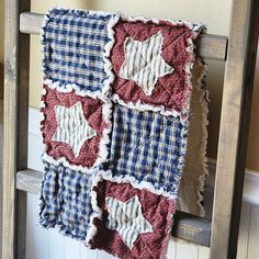 an old ladder is decorated with red, white and blue quilts that have stars on them