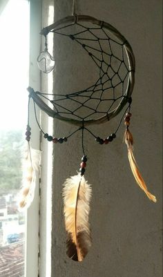 a dream catcher hanging from the side of a window