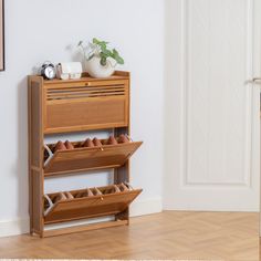 there is a shoe rack in the corner with shoes on it and a vase next to it