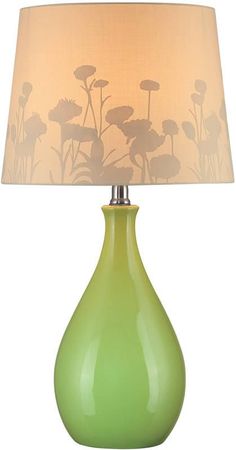 a green table lamp with a white shade on the top and flowers on the bottom