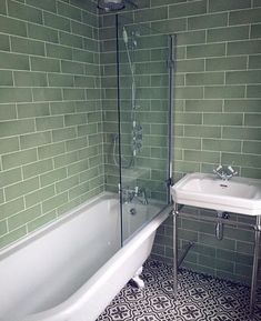 a white bath tub sitting next to a sink under a faucet in a bathroom