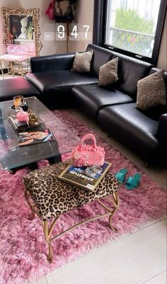 a living room with black leather couches and leopard print rugs on the floor