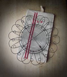 a piece of cloth with scissors on it sitting on top of a wooden table next to a red ribbon