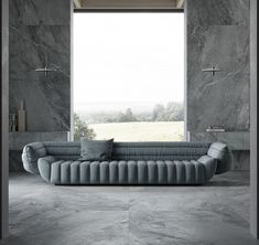 a large gray couch sitting in front of a window