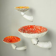 three white and red dishes flying in the air with one orange bowl sitting on top of it