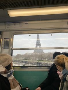 two women on a train looking out the window at the eiffel tower