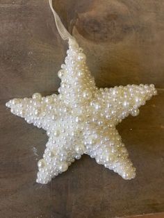 a white starfish ornament hanging on a wooden surface