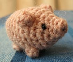 a crocheted hamster sitting on top of a blue blanket