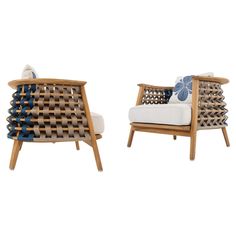 two wooden chairs with blue and white pillows on top of each chair, side by side