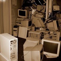 a room full of old computers and other electronic equipment in black and white photo, with one computer sitting on the floor