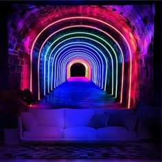 a white couch sitting under a tunnel filled with neon colored lights in a dark room